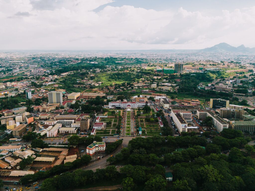 Aerial view over a city centre, with a formal garden square, a boulevard and hills in the distance