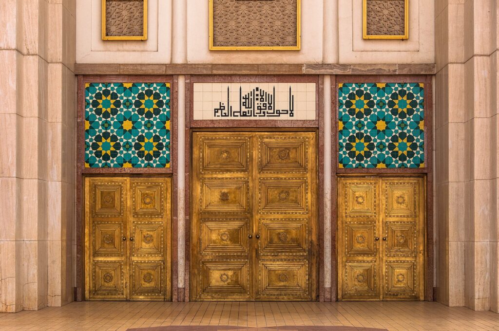 Gold-coloured doors and blue patterned tiles at the main entrance of the Abuja National Mosque