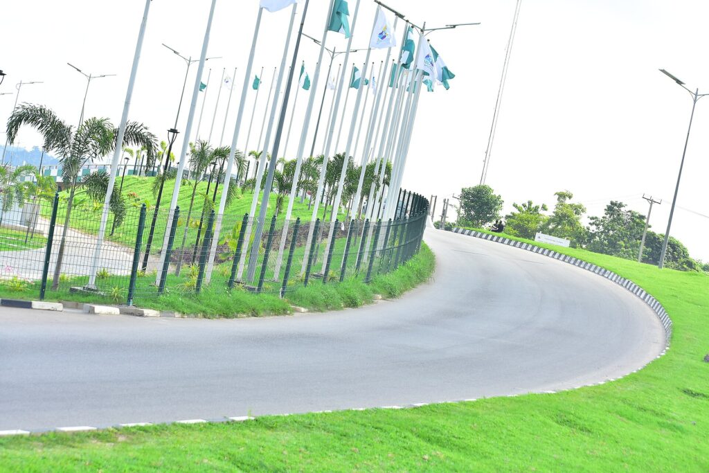 Nigerian flags lining a curving road at the Abuja City Gate
